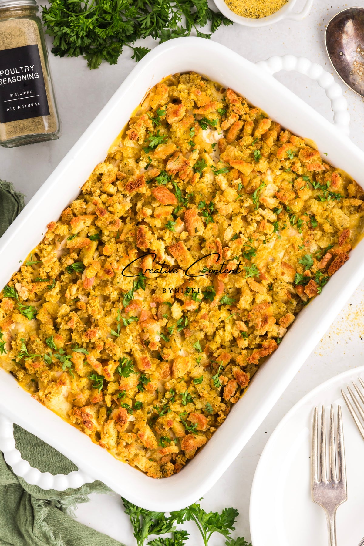 Church Cookbook Chicken Casserole - Exclusive in a white rectangular baking dish, topped with a golden-brown crust and sprinkled with parsley.