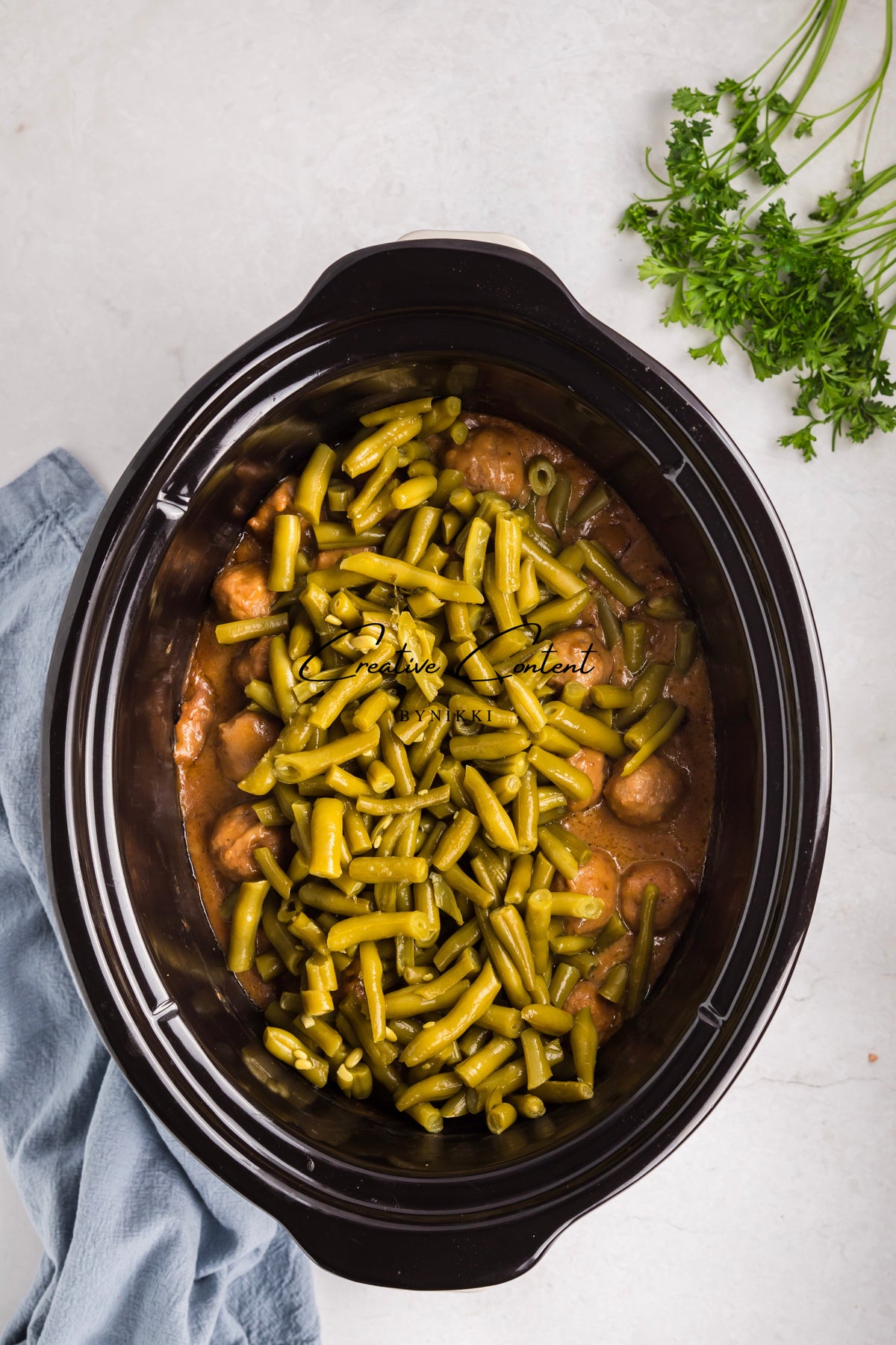 A Crock Pot Smothered Meatballs and Green Beans - Exclusive filled with meatballs and green beans in a savory sauce.