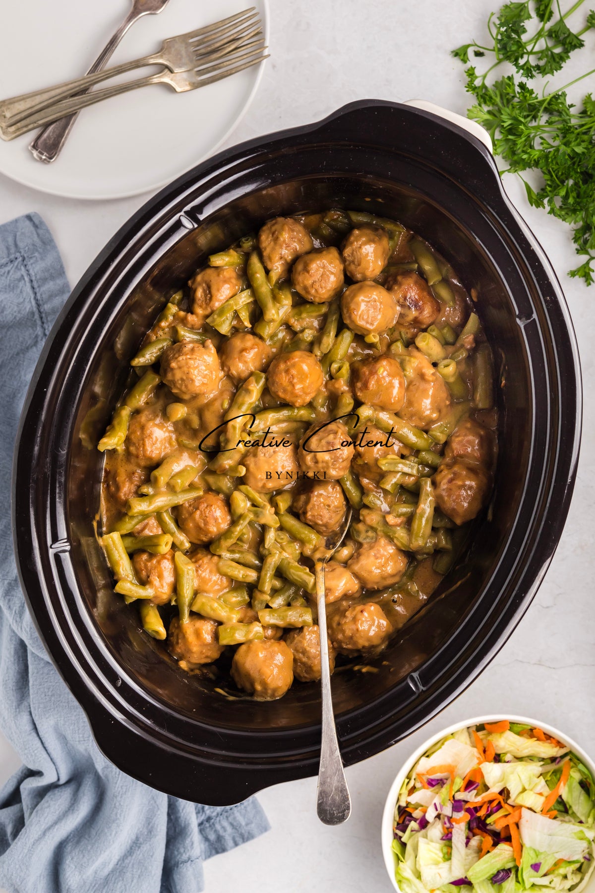 Crock Pot Smothered Meatballs and Green Beans - Exclusive served in a slow cooker in brown gravy with a side of coleslaw.