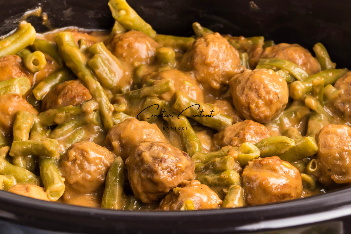 Crock Pot Smothered Meatballs and Green Beans cooking in a creamy brown sauce.
