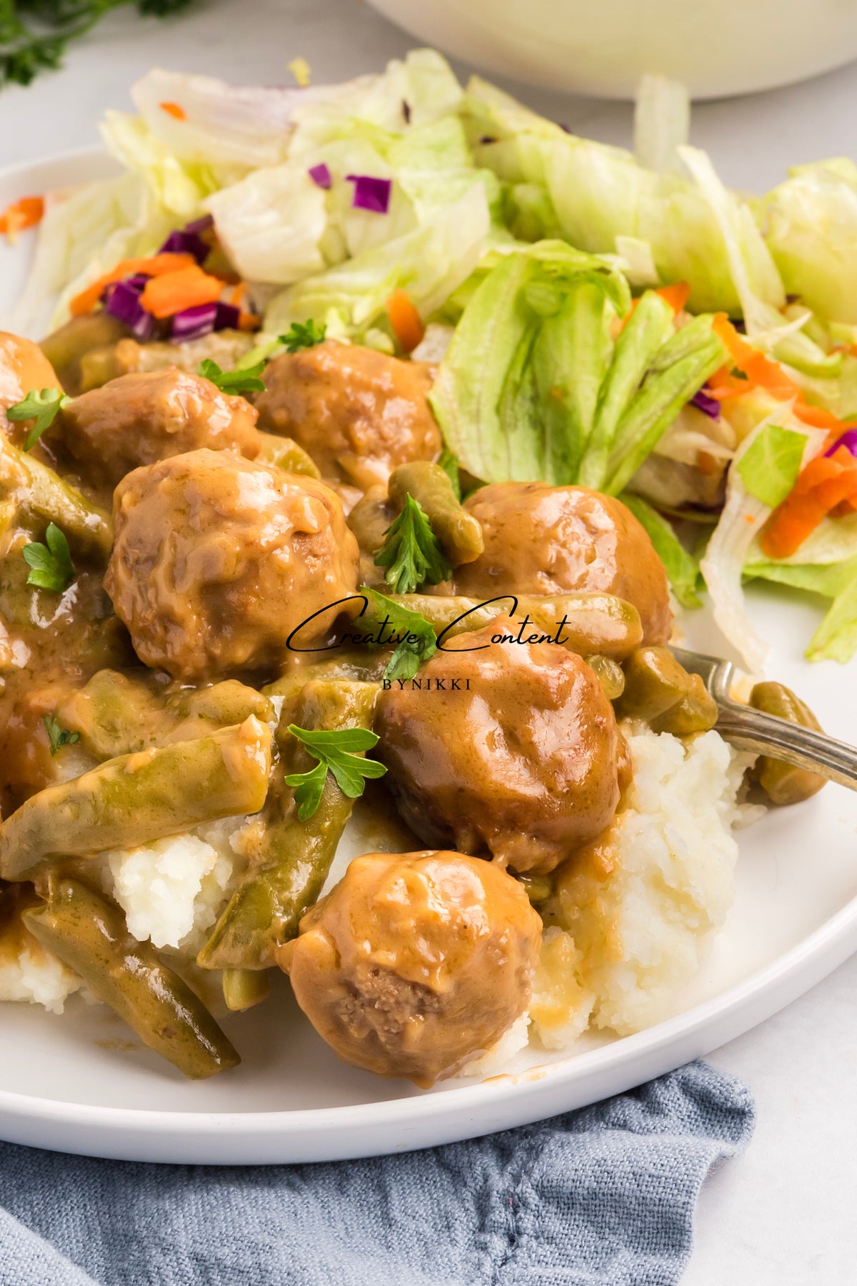 Crock Pot Smothered Meatballs and Green Beans - Exclusive served over mashed potatoes with a side of lettuce salad.