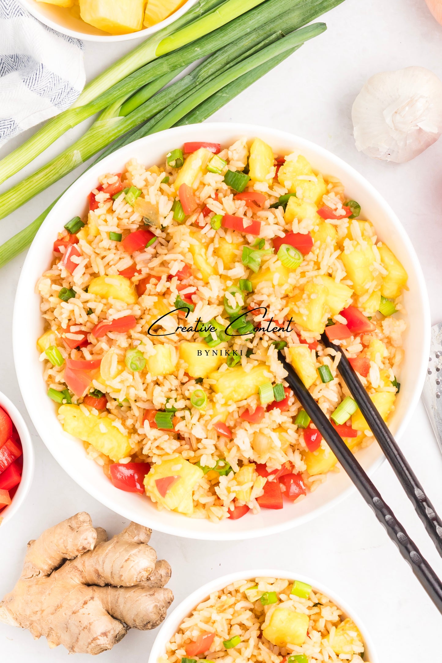  bowl of fried rice with vegetables on a white surface